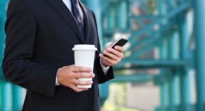 Agent on the go with coffee and smartphone