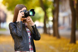 young photographer take photos outdoors in park