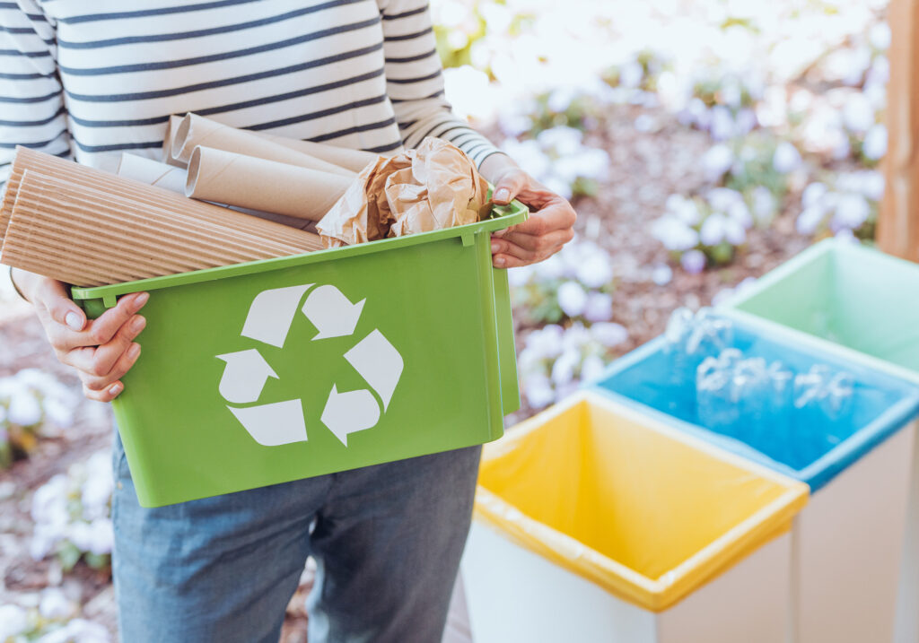 man throwing trash into recycling containers