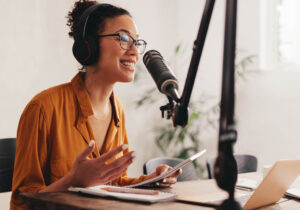 Woman talking on a microphone, recording a podcast