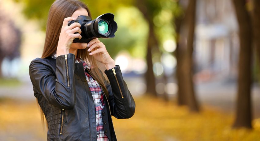 young photographer take photos outdoors in park